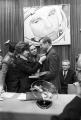 Првата жена во вселената, Валентина Терешкова, му дава орден и му оддава почит на Нил Армстронг, под сликата ги гледа Јуриј Гагарин, првот човек во Вселената