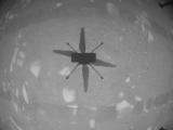 Сенката на Ingenuity на површината на Црвената планета. Фотографијата е направана од камерите на хеликоптерот за време на првиот контролиран моторен лет. (NASA/JPL)