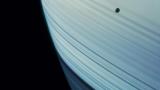 Месечината Мимас во преден план пред сатурновите прстени и дел од пречникот на огромниот гасен џин