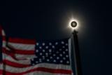 Целосно затемнување на Сонцето се гледа покрај развиорено американско знаме во Хултон, Мејн